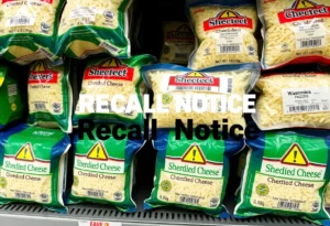 Shredded cheese packages marked with a recall notice in a grocery store.