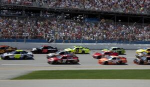 NASCAR stock cars racing past a full grandstand